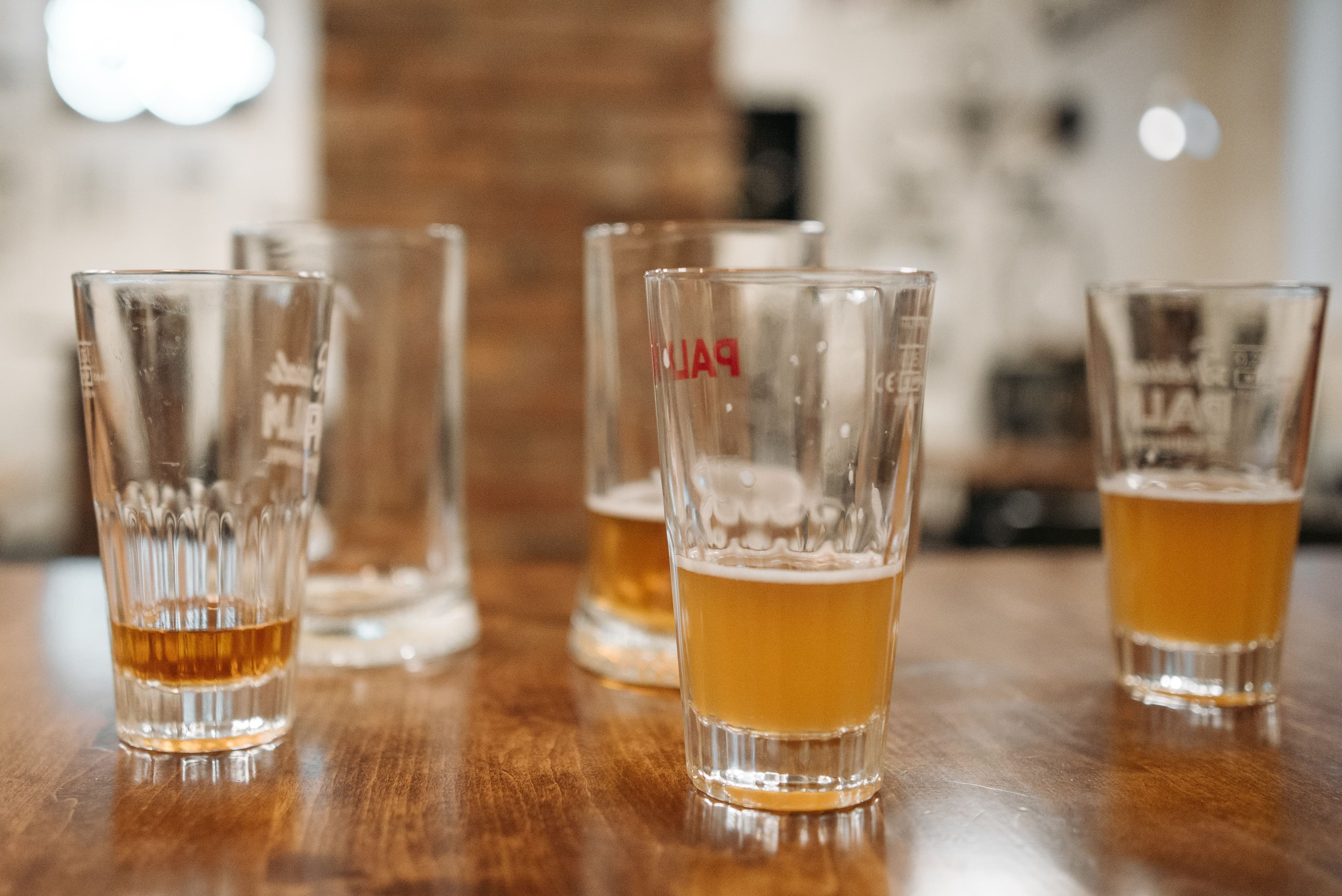 Mehrere frisch gezapfte Biere auf einem Holztisch